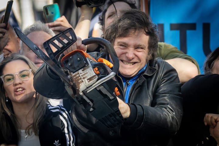 President Javier Milei of Argentina holding a chainsaw at a campaign event.