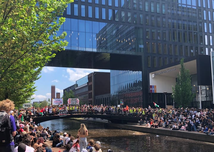 Protest on both sides of a canal and on a bridge at the University of Amsterdam, 2024.